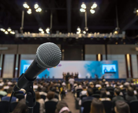 Microphone with Abstract blurred photo of conference hall or meeting room with attendee background, business and education concept